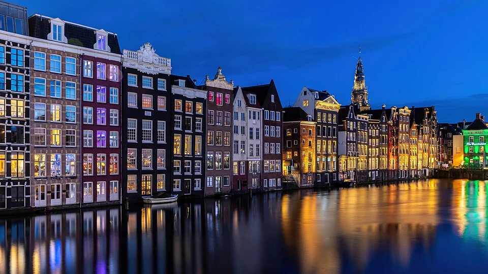 Amsterdam’s canal houses reflected in the Damrak at blue hour